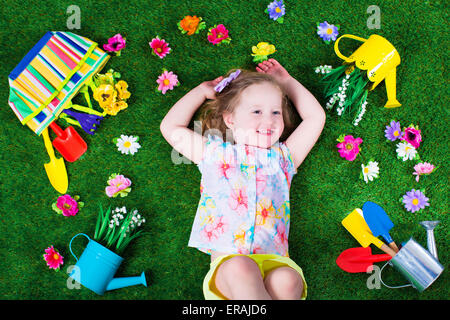 Kinder im Garten. Kinder mit Gartengeräten. Kind mit Gießkanne und Schaufel. Kleines Kind Blumen gießen. Stockfoto