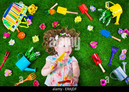 Kinder im Garten. Kinder mit Gartengeräten. Kind mit Gießkanne und Schaufel. Kleines Kind Blumen gießen Stockfoto