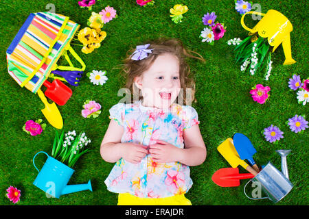 Kinder im Garten. Kinder mit Gartengeräten. Kind mit Gießkanne und Schaufel. Kleines Kind Blumen gießen. Stockfoto