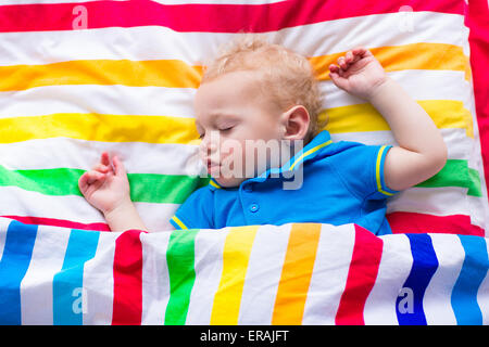 Kinder schlafen im Bett der bunten. Kleinen Jungen schlafen. Kinder Textil in Regenbogen Farbe. Kleinkind Kind Entspannung an einem sonnigen Morgen. Stockfoto