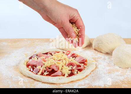 Kochen Sie geriebenen Käse bestreuen, über pizza Stockfoto