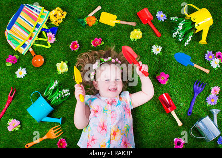 Kinder im Garten. Kinder mit Gartengeräten. Kind mit Gießkanne und Schaufel. Kleines Kind Blumen gießen. Stockfoto