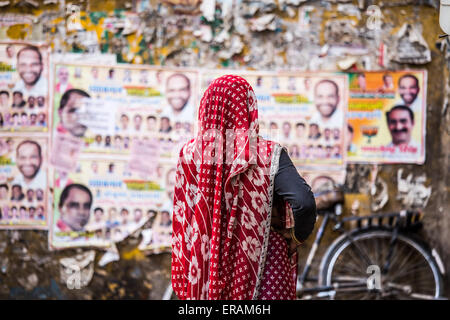 Indische Frau stand vor Abstimmung Plakate in Delhi, Indien Stockfoto