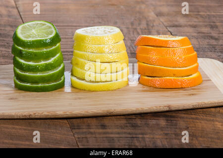 Stapel von Zitrone, Limette und Orange Scheiben auf Schneidebrett Stockfoto