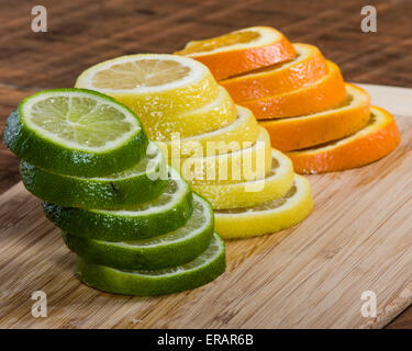 Stapel von Zitrone, Limette und Orange Scheiben auf Schneidebrett Stockfoto