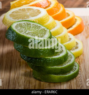 Stapel von Zitrone, Limette und Orange Scheiben auf Schneidebrett Stockfoto