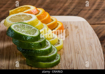 Stapel von Zitrone, Limette und Orange Scheiben auf Schneidebrett Stockfoto