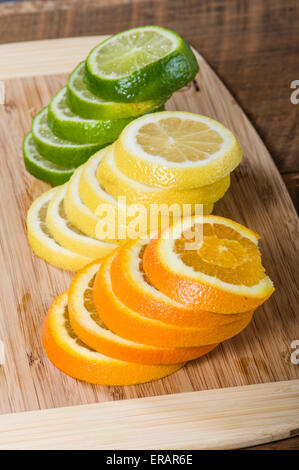 Stapel von Zitrone, Limette und Orange Scheiben auf Schneidebrett Stockfoto