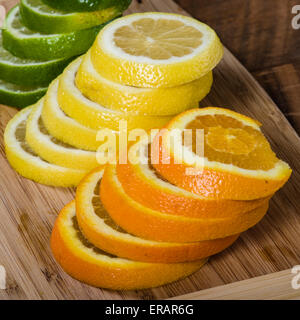 Stapel von Zitrone, Limette und Orange Scheiben auf Schneidebrett Stockfoto