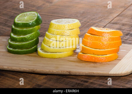 Stapel von Zitrone, Limette und Orange Scheiben auf Schneidebrett Stockfoto