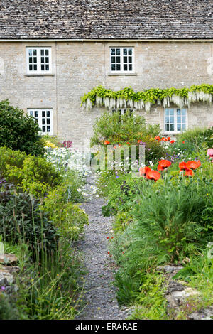 Blumengarten und Weg vor einem Haus in Ablington. Cotswolds, Gloucestershire, England Stockfoto