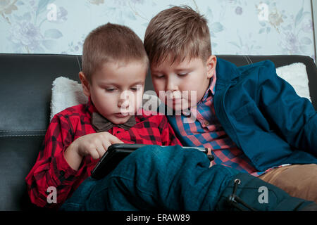 zwei kleine Jungen Geschäftsmann mit Tablet-PC auf einem dunklen Hintergrund isoliert Stockfoto