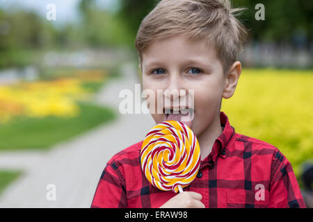 glücklich kleiner Junge mit großen Süßigkeiten im freien Stockfoto