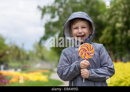 glücklich kleiner Junge mit großen Süßigkeiten im freien Stockfoto