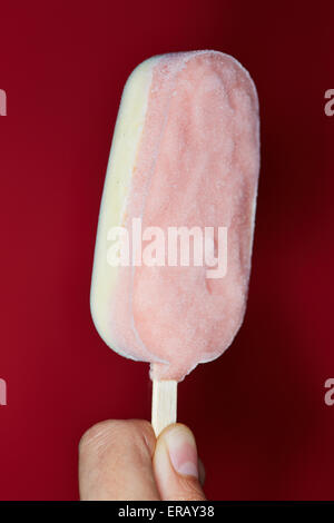 Hand hält Eis Sahne Eis am Stiel mit zwei Geschmacksrichtungen Stockfoto