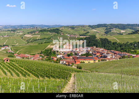 Kleine Stadt Barolo zwischen Hügeln mit grünen Weinberge unter blauem Himmel im Piemont, Norditalien. Stockfoto