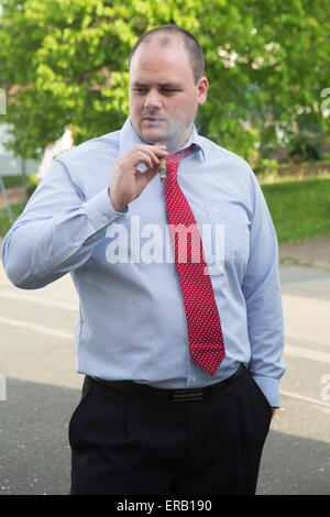 Mann in Hemd und Krawatte, raucht eine Zigarre Stockfoto