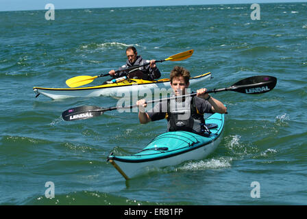 Kajakfahren auf dem Meer vor der Küste von Anglesey, Wales, Großbritannien Stockfoto