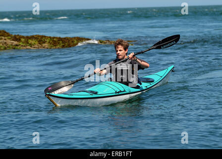 Kajakfahren auf dem Meer vor der Küste von Anglesey, Wales, Großbritannien Stockfoto