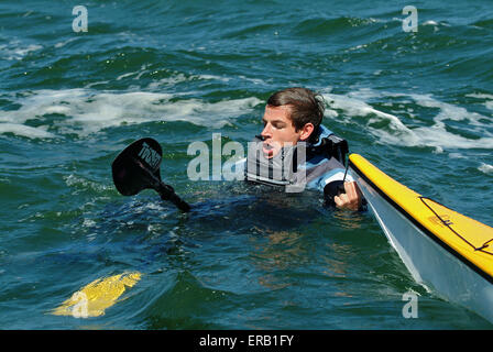 Kajakfahren auf dem Meer vor der Küste von Anglesey, Wales, Großbritannien Stockfoto