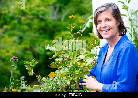 Portrait einer älteren Frau auf ihrem Balkon und lächelnd Stockfoto