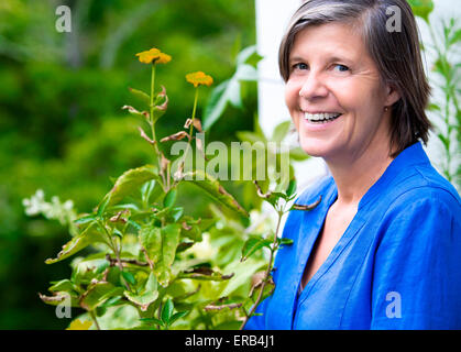 Portrait einer älteren Frau auf ihrem Balkon und lächelnd Stockfoto