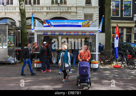 Einheimische und Touristen an einem Amsterdams berühmten Hering Straße shop Stockfoto