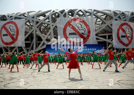 Peking, China. 31. Mai 2015. Tänzer vor Anti-Raucher-Banner angezeigt auf des legendären Vogels Nest Nationalstadion am Weltnichtrauchertag in Peking, Hauptstadt von China, 31. Mai 2015. Beijing plant neue Regelungen am 1. Juni, erfordern alle geschlossenen öffentlichen Orten- und viele Outdoor-öffentliche Orte - zu 100 % rauchfrei. Die Gesetzgebung gilt als das strengste Anti-Raucher-Gesetz in der Geschichte Chinas. © Shen Bohan/Xinhua/Alamy Live-Nachrichten Stockfoto