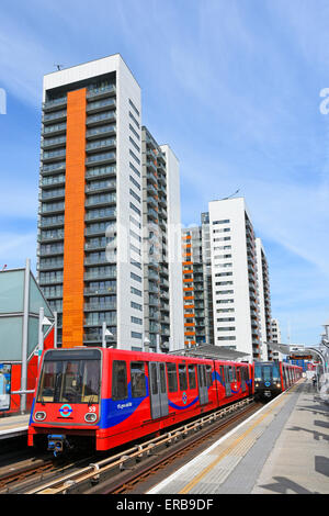 Moderne Wohnhäuser in Blöcken Hochhäuser neben Docklands Light Railway Züge an East India DLR Bahnsteig East London England UK Stockfoto