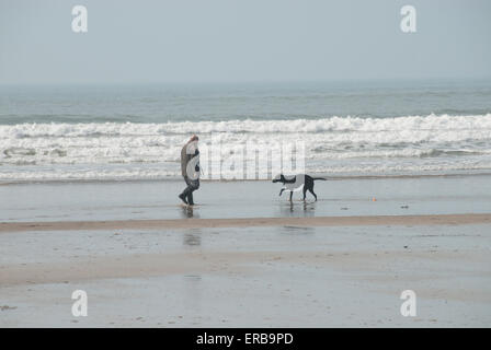 Mensch und Hund am Strand von Westward Ho! in Nord-Devon Stockfoto