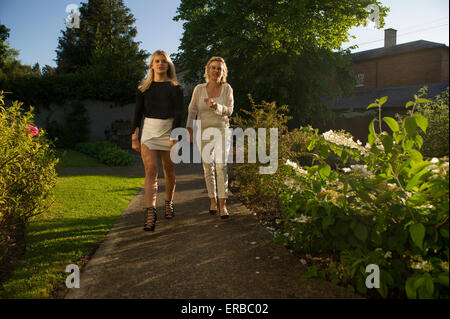 Eine Mutter und Tochter gehen in Richtung der Kamera in einem schönen Abendlicht Stockfoto