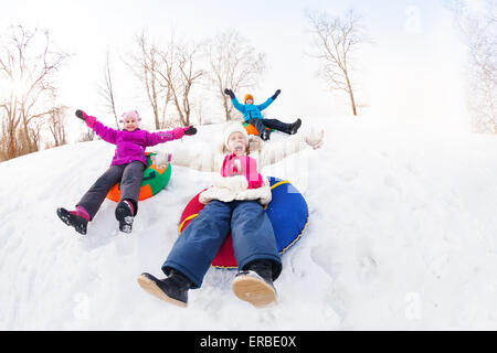 Aufgeregte Gruppe von Kindern auf Röhren Rutschen Stockfoto