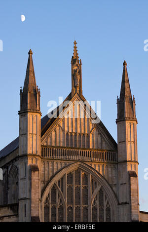 Die westliche Fassade (oder Westfront) der gotischen Winchester Cathedral bei Dämmerung mit dem Mond über dem Himmel, Hampshire, Großbritannien Stockfoto