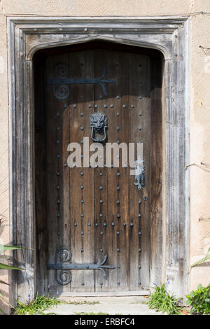 Alte braune Holztür mit Metall-Nieten und reich verzierten Scharniere - auf historischen Gebäude in der Nähe von Lapworth, England Stockfoto