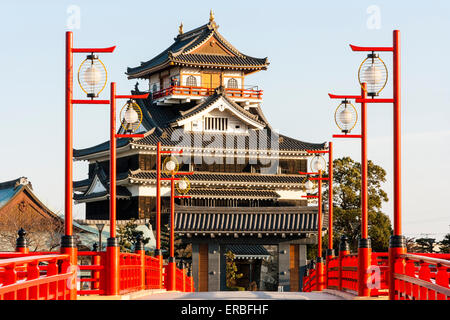 Japan, Nagoya. Betonrekonstruktion der Holzbrücke mit Melionengeländern und Lampen, die zur Burg Kiyosu mit blauem Himmelshintergrund führt. Stockfoto