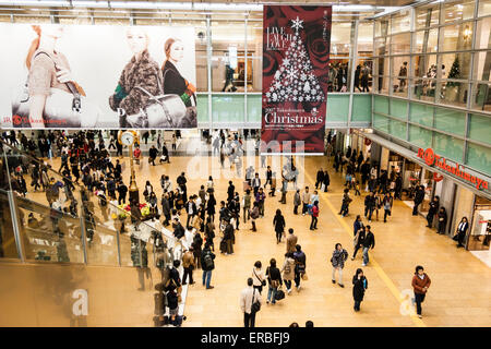 Innenansicht des Bahnhofs Nagoya zur Weihnachtszeit. Blick von oben auf die große, geschäftige Piazza im Inneren mit vielen Menschen zu Fuß. Rolltreppe links. Stockfoto