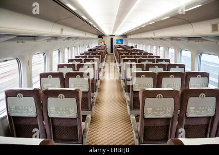 Interieur der japanischen shinkansen, Hochgeschwindigkeitszug, Serie 700, Standard-Klasse Eisenbahnwagen während der Reise. Wagen ist fast emty. End-to-End-Ansicht. Stockfoto