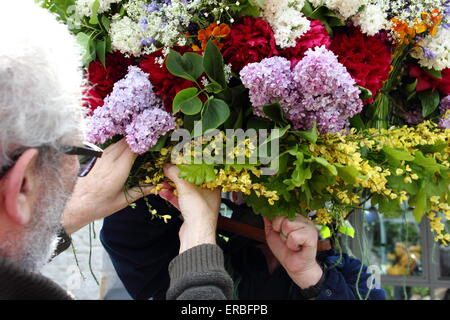 Girlande-Hersteller Schliff den letzten an der floralen Kopfschmuck getragen durch die Girlande King Oak Apple Day, Castleton feiern Stockfoto