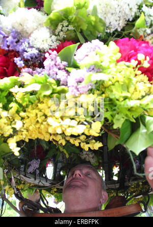 Eine Girlande Maker verleiht den letzten Schliff der Flora Kopfschmuck getragen durch die Girlande King Oak Apple Day, Castleton feiern Stockfoto