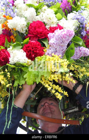 Eine Girlande Maker verleiht den letzten Schliff der Flora Kopfschmuck getragen durch die Girlande King Oak Apple Day, Castleton feiern Stockfoto