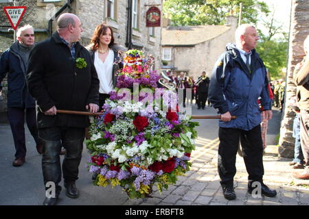 Ein floraler Kopfschmuck ist durch die Straßen von Castleton, Derbyshire als Teil der Stadt Oak Apple Day Feierlichkeiten vorgeführt. Stockfoto