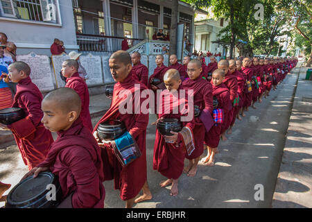 Mönche aufgereiht für die letzte Mahlzeit des Tages im Kloster Amarapura, Mandalay Myanmar Stockfoto