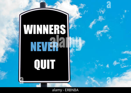 Gewinner nie aufhören motivierenden Zitat geschrieben am Schild über blauen Himmelshintergrund mit verfügbaren textfreiraum isoliert. Stockfoto