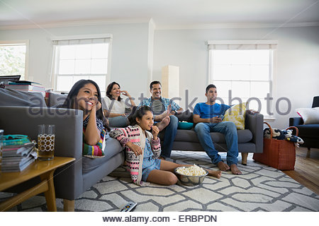 Familie vor dem Fernseher mit Popcorn im Wohnzimmer