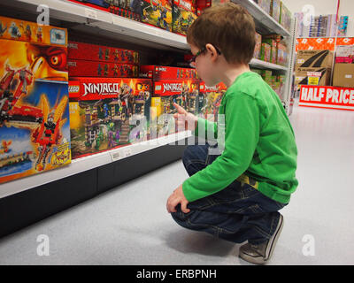 Ein kleiner Junge auf der Suche bei Lego in einem Spielzeugladen Stockfoto