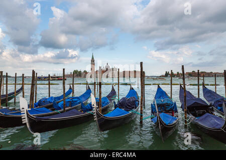 Gondeln fahren in ihre Liegeplätze in der Nähe von Markusplatz mit Chiesa di San Giorgio Maggiore im Hintergrund Stockfoto