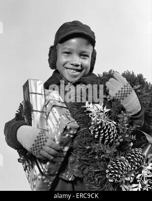 1940ER JAHRE WEIHNACHTSGESCHENKE AFRICAN AMERICAN BOY KRANZ Stockfoto