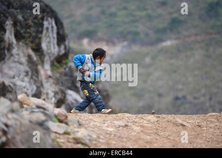 (150601)--DAHUA, 1. Juni 2015 (Xinhua)--Schüler Meng Weiyi schlägt einen Kreisel in Nongyong Dorf dann Township im Dahua Yao autonome Grafschaft, 7. März 2015. Juni 1 markiert den Internationalen Kindertag. (Xinhua/Huang Xiaobang) (Lfj) Stockfoto