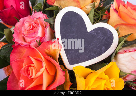 Rosen und Schreibtafel in Herzform, Nahaufnahme Stockfoto