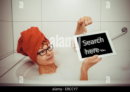 Frau in der Badewanne mit Tablet-PCs, Raum für Text, Retro-Stil Stockfoto
